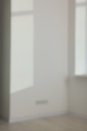 Blurred view of light and shadows from window on wall indoors