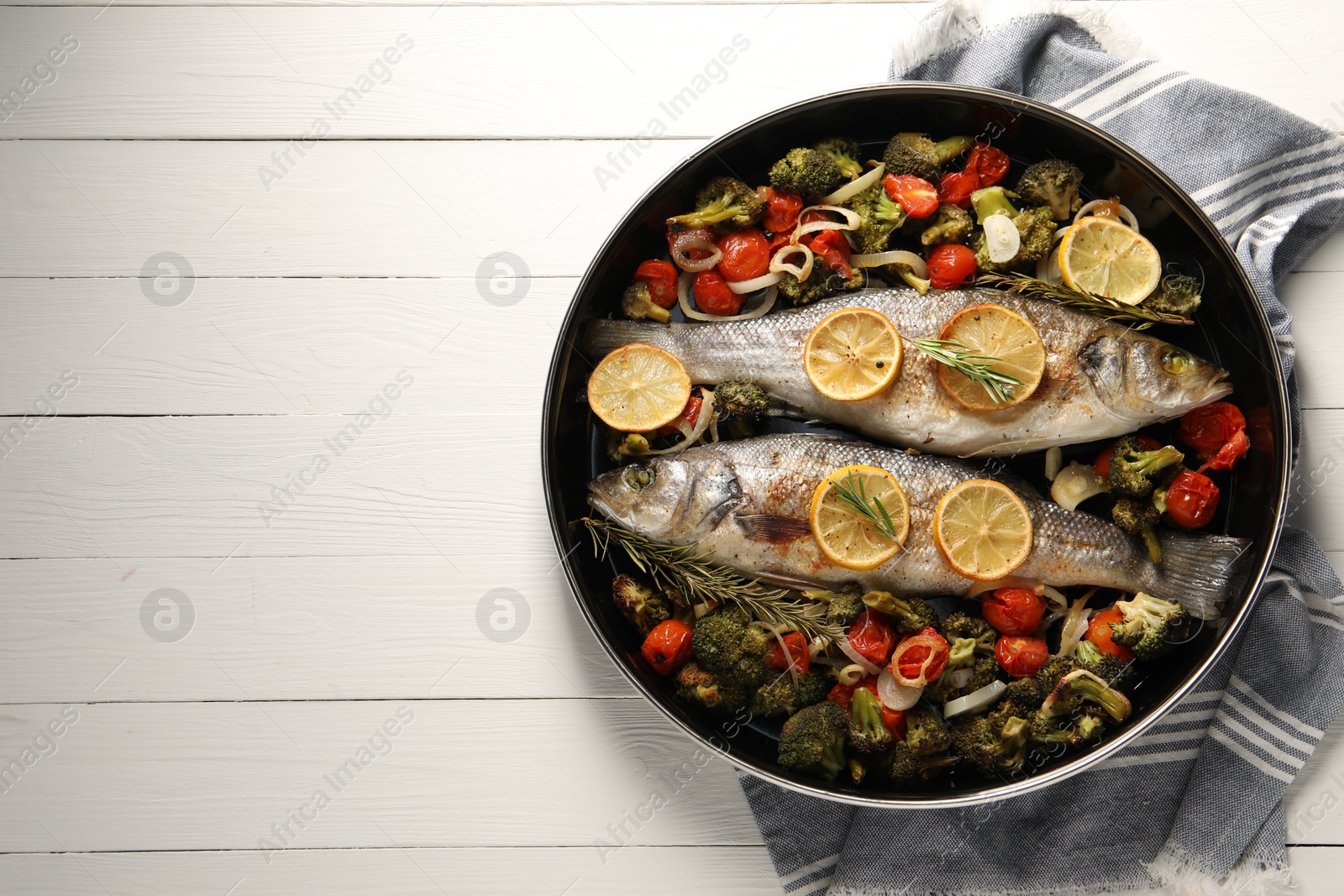 Photo of Baked fish with vegetables, rosemary and lemon on white wooden table, top view. Space for text