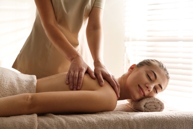 Young woman receiving back massage in spa salon