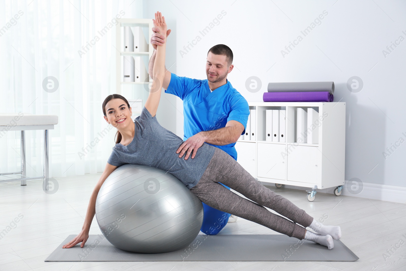 Photo of Doctor working with patient in hospital. Rehabilitation exercises