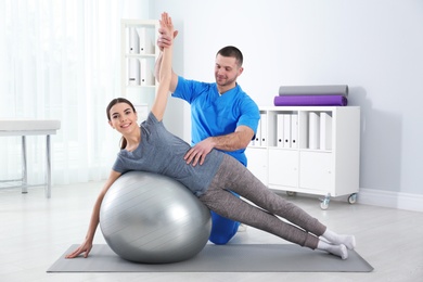 Photo of Doctor working with patient in hospital. Rehabilitation exercises