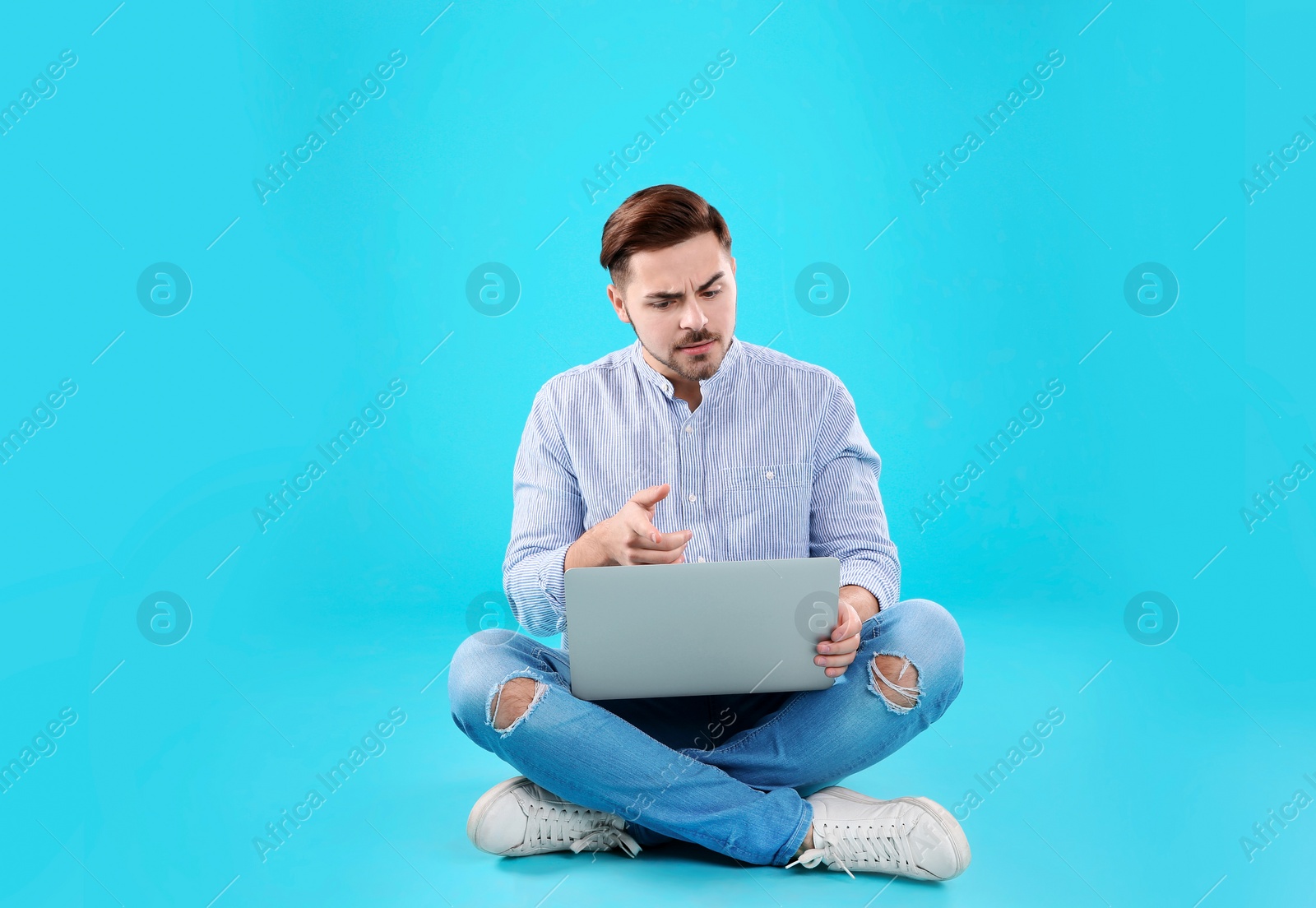 Photo of Man using laptop for video chat on color background