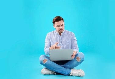 Man using laptop for video chat on color background