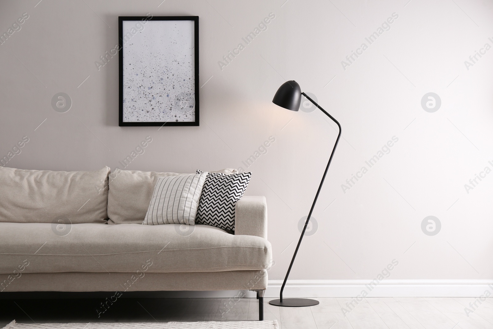 Photo of Stylish living room interior with comfortable sofa and floor lamp. Space for text