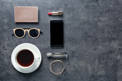 Photo of Flat lay composition with cup of coffee, smartphone and stylish accessories on grey background. Blogger concept