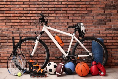 Photo of Bicycle and different modern sport equipment near brick wall