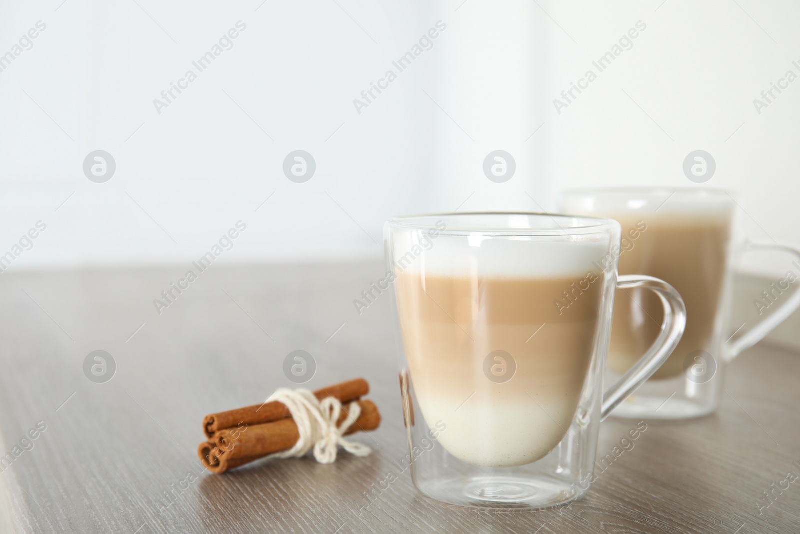 Photo of Delicious latte macchiato on wooden table indoors. Space for text