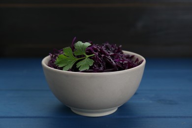 Photo of Tasty red cabbage sauerkraut with parsley on light blue wooden table