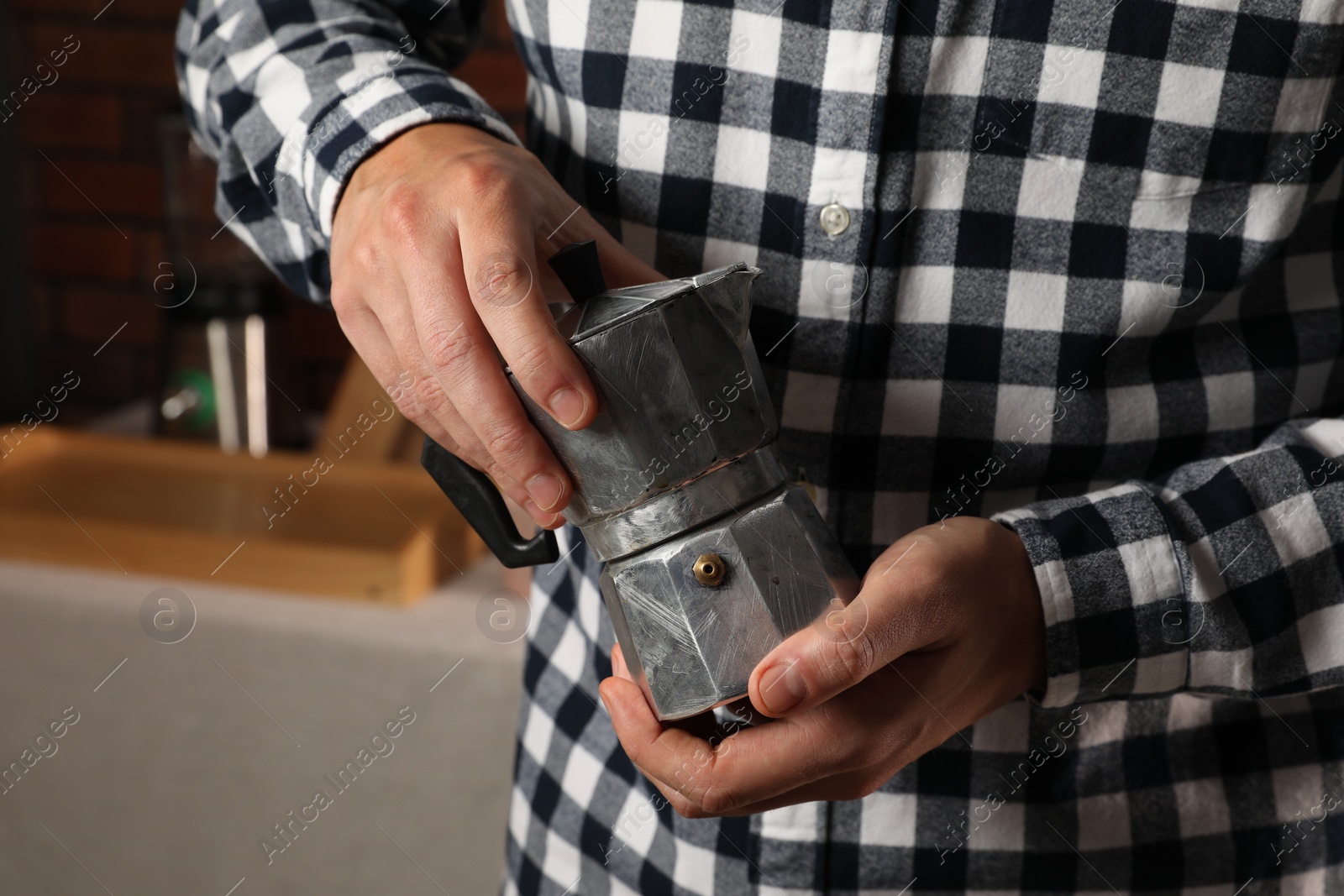 Photo of Man holding coffee moka pot indoors, closeup
