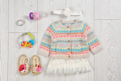 Photo of Flat lay composition with stylish child clothes and accessories on wooden background