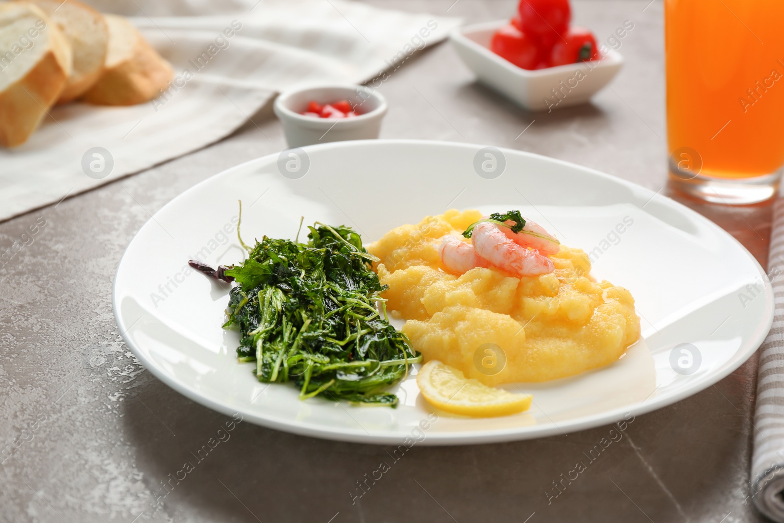 Photo of Plate with fresh tasty shrimp and grits on table