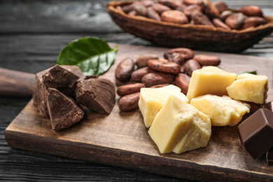 Organic cocoa butter and chocolate on wooden table, closeup
