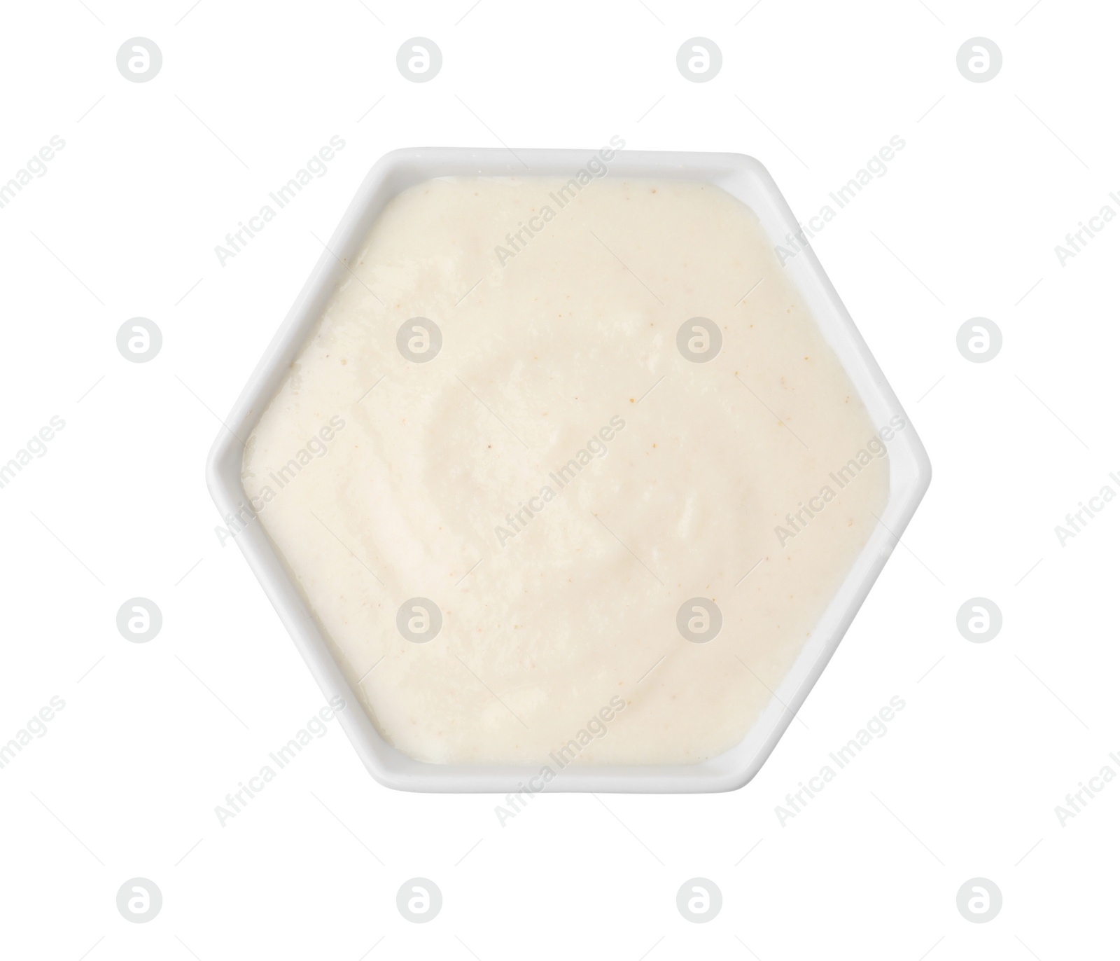 Photo of Bowl of delicious semolina pudding isolated on white, top view