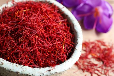 Photo of Dried saffron and crocus flowers on table, closeup