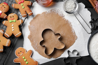 Flat lay composition with homemade gingerbread man cookies on black table