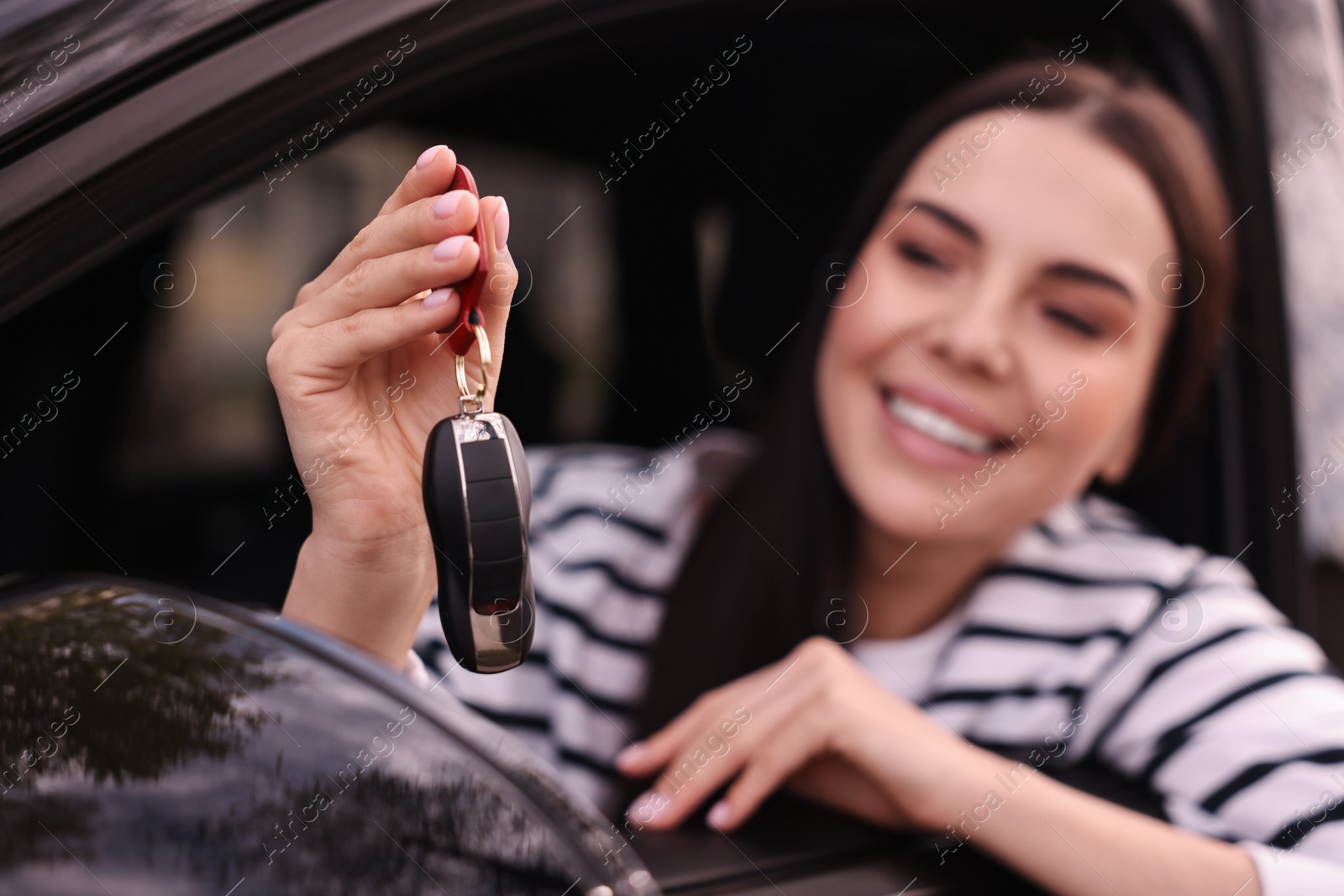 Photo of Woman holding car flip key inside her vehicle, selective focus