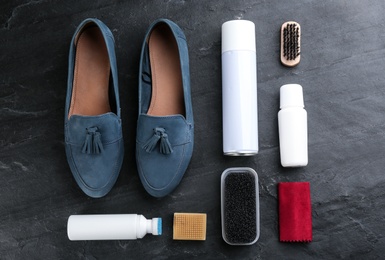 Stylish footwear with shoe care accessories on black table, flat lay