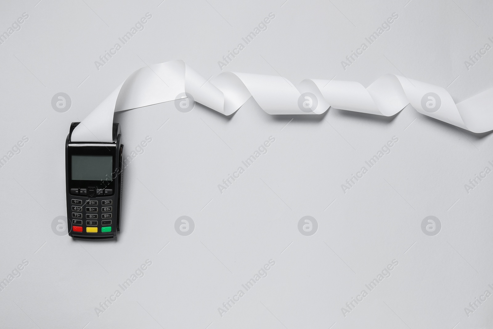 Photo of Payment terminal with thermal paper for receipt on light grey background, top view. Space for text