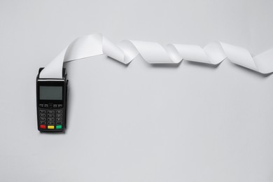 Payment terminal with thermal paper for receipt on light grey background, top view. Space for text