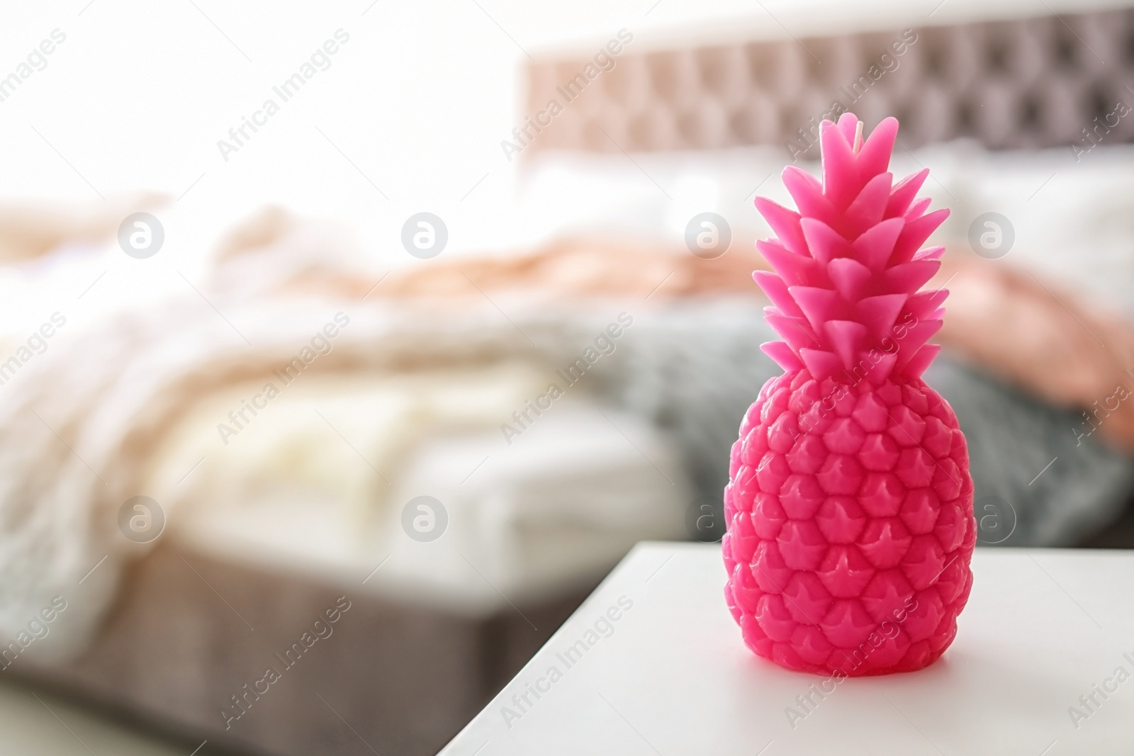 Photo of Pineapple shaped candle on table in room