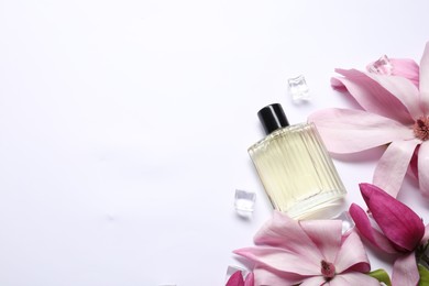 Photo of Beautiful pink magnolia flowers, bottle of perfume and ice cubes on white background, flat lay. Space for text