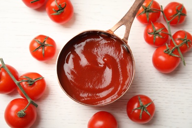 Dishware with tasty homemade tomato sauce and fresh vegetables on white wooden background, top view