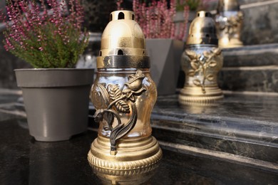 Photo of Golden grave lanterns on granite stairs at cemetery