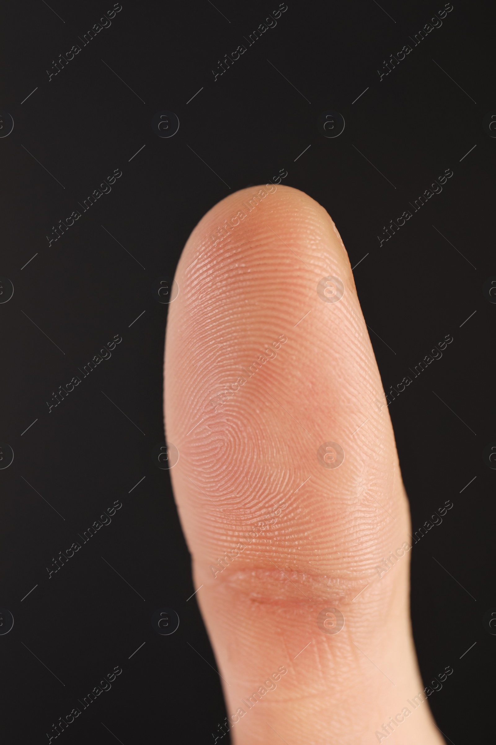 Photo of Man scanning fingerprint on black background, closeup