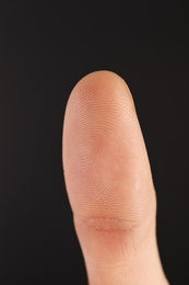 Photo of Man scanning fingerprint on black background, closeup