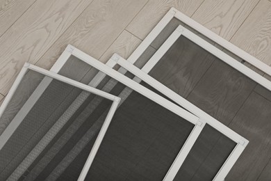 Photo of Set of window screens on wooden floor, closeup