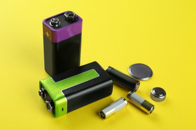 Image of Different types of batteries on yellow background