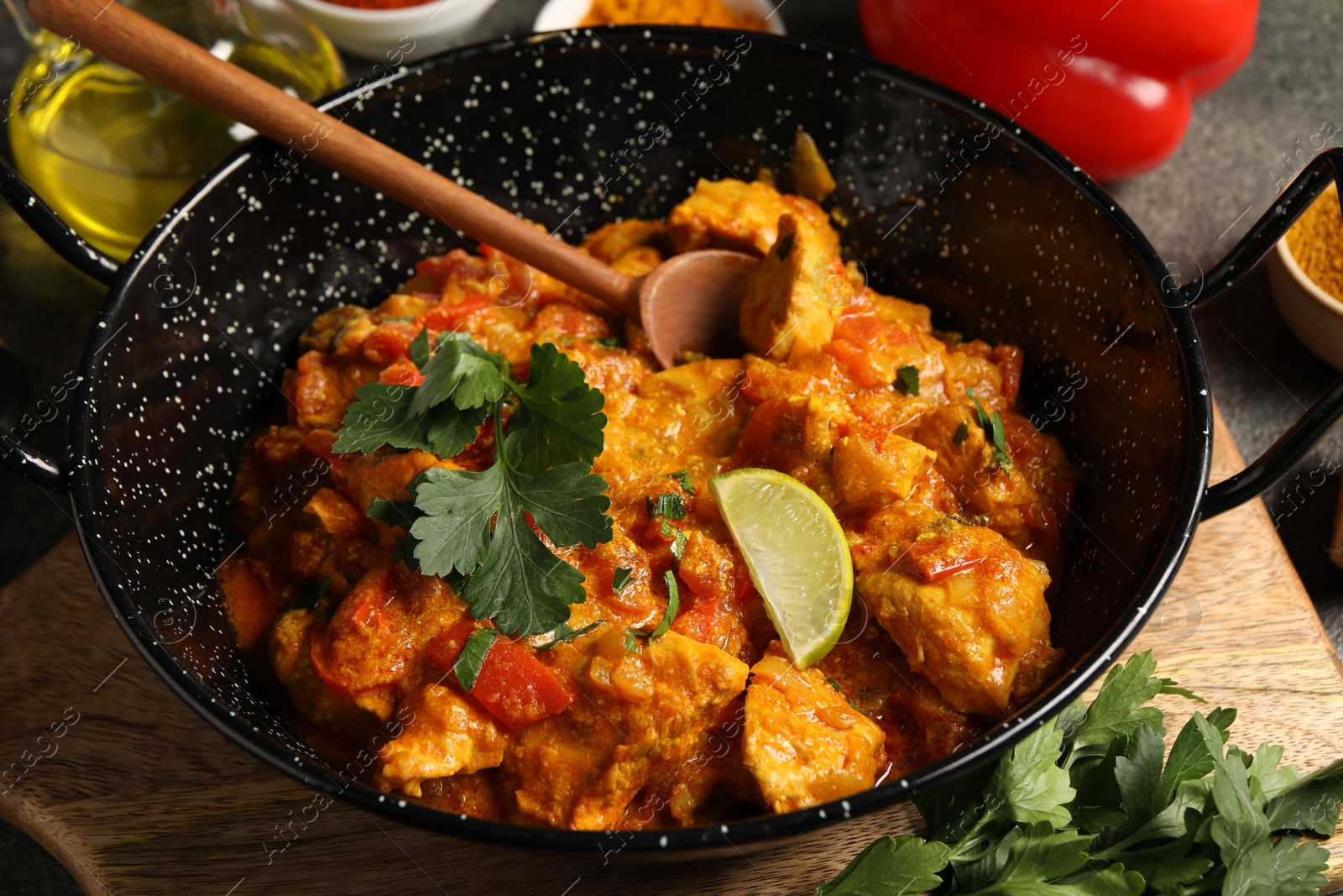 Photo of Delicious chicken curry in frying pan on table, closeup