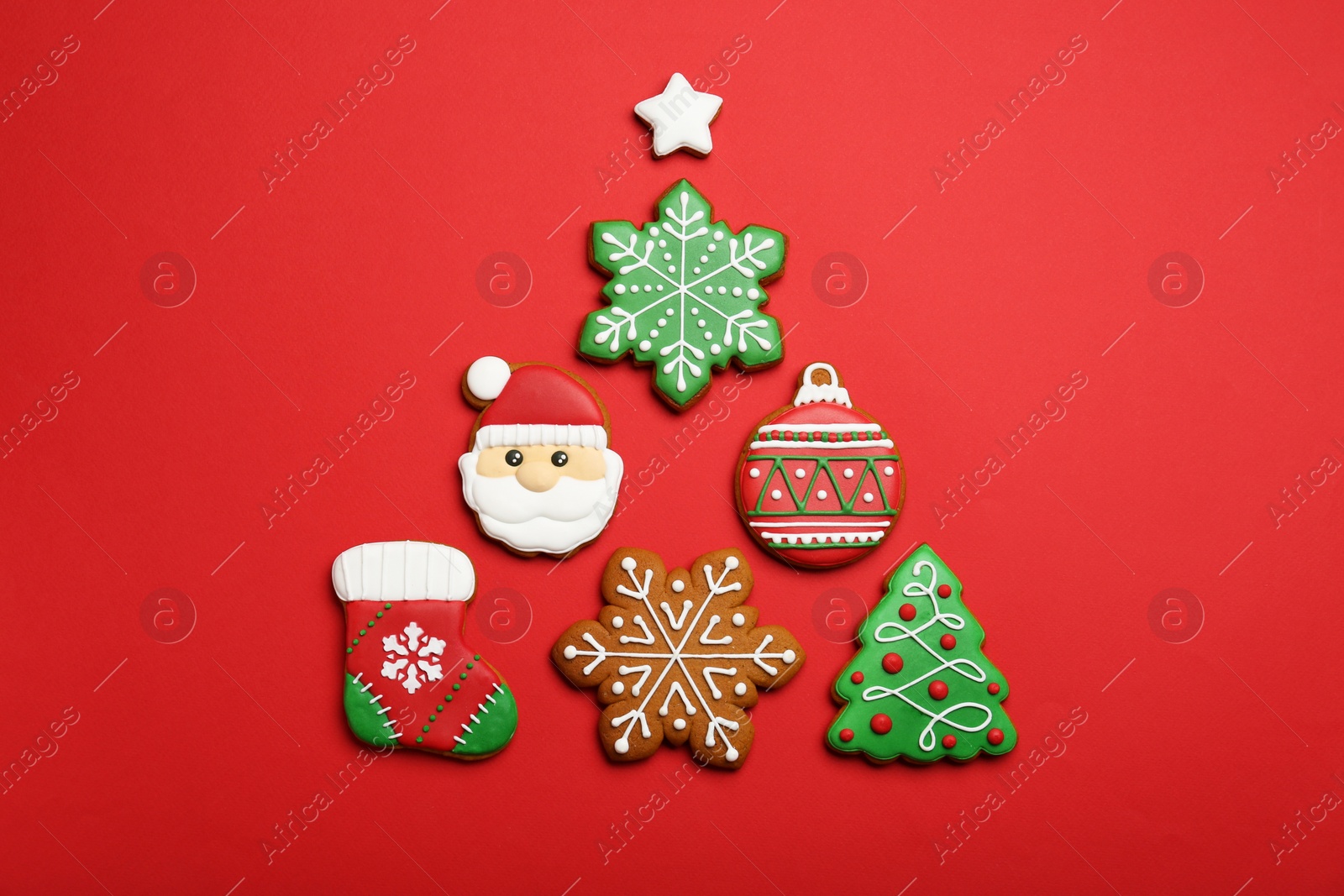 Photo of Different tasty Christmas cookies on red background, flat lay