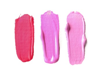 Photo of Samples of pink paint on white background, top view