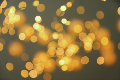 Photo of Blurred view of gold lights on dark background. Bokeh effect