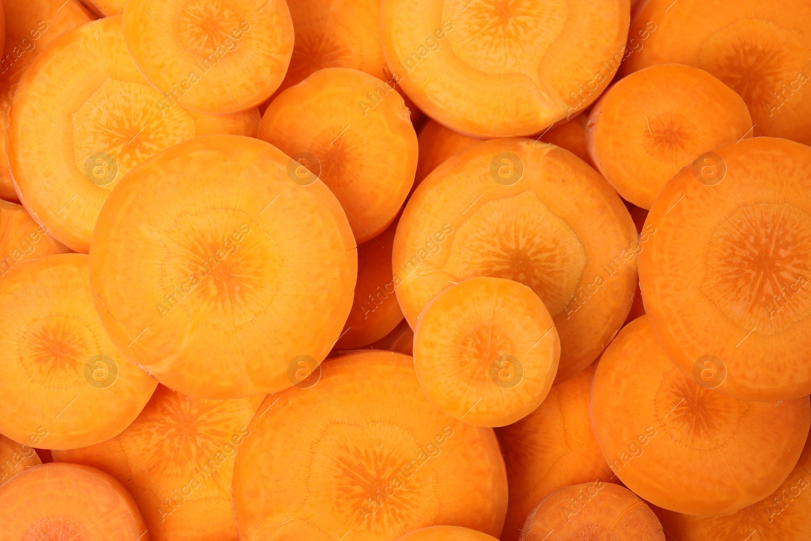 Photo of Slices of fresh ripe carrots as background, top view