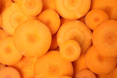 Photo of Slices of fresh ripe carrots as background, top view