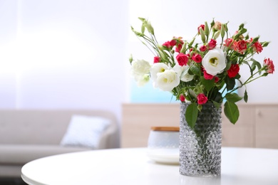 Photo of Vase with beautiful flowers on white table in room, space for text