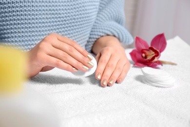 Photo of Woman removing nail polish on towel, closeup