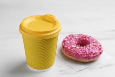 Tasty donut and cup of hot drink on white marble table