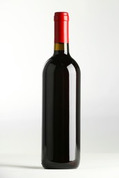 Photo of Bottle of expensive red wine on white background