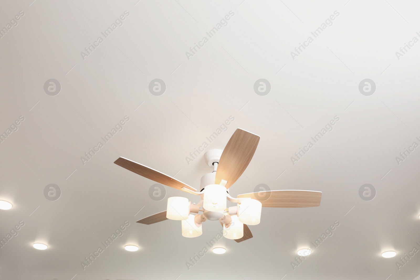 Photo of Modern ceiling fan with lamps indoors, below view