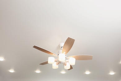 Photo of Modern ceiling fan with lamps indoors, below view