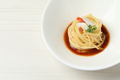 Tasty spaghetti with sauce on white wooden table, closeup and space for text. Exquisite presentation of pasta dish