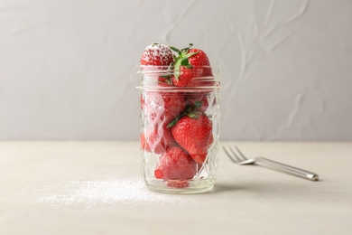 Photo of Glass jar with ripe red strawberries on table