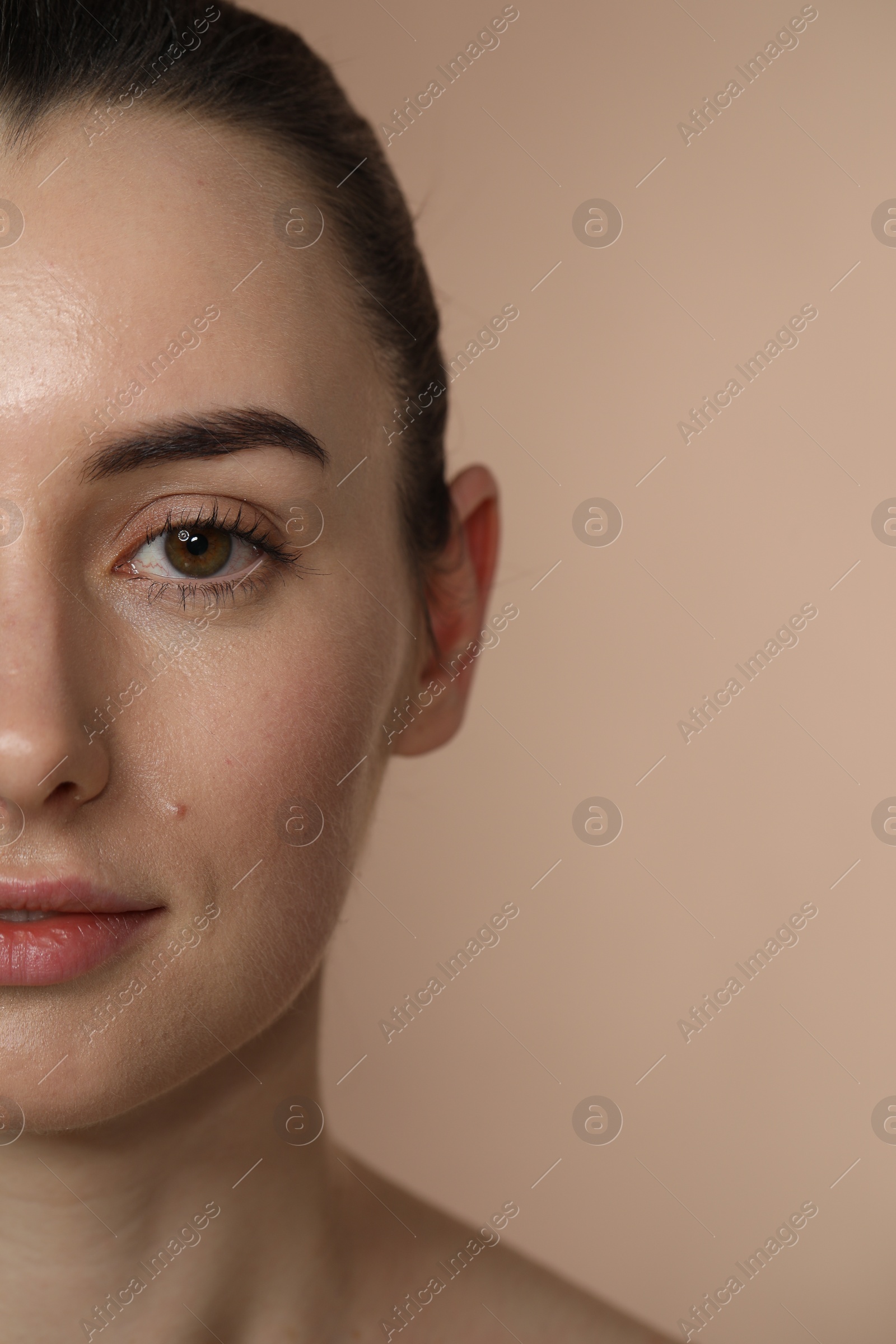 Photo of Beautiful young woman with healthy skin on light brown background, closeup