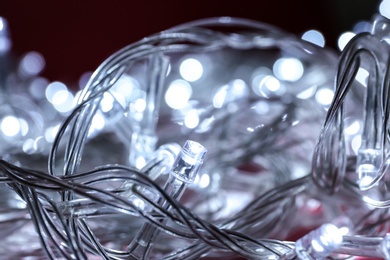 Photo of Glowing Christmas lights on dark background, closeup