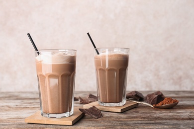 Glasses with chocolate milk shakes on wooden table