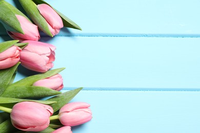 Photo of Happy Mother's Day. Beautiful pink tulips on light blue wooden table, flat lay. Space for text