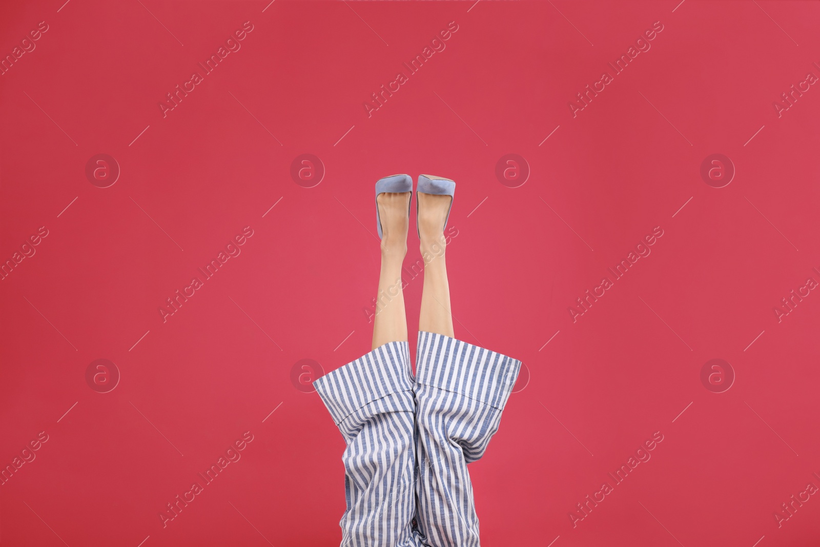 Photo of Woman in elegant shoes on crimson background